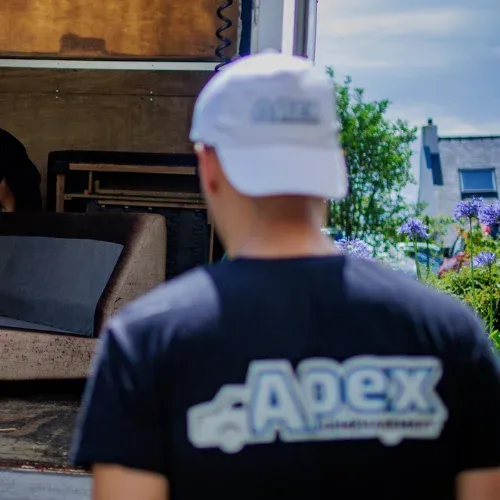 Déménageur Apex en casquette devant un camion chargé